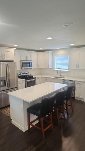 a kitchen with a white counter and chairs in it at Angelic in Tacoma