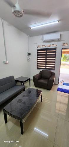 a living room with a couch and a coffee table at Homestay Mak Ndek '4' in Muar