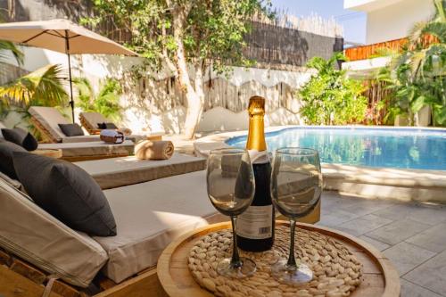 a bottle of wine and two glasses on a table at La Veleta Hotel - Pool Access Room in Tulum