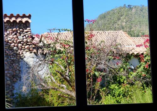 a window with a view of a building with flowers at Hotel Villa Antigua in Sucre