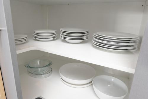 a white cabinet filled with plates and bowls at Grove Park Motor Lodge in Blenheim