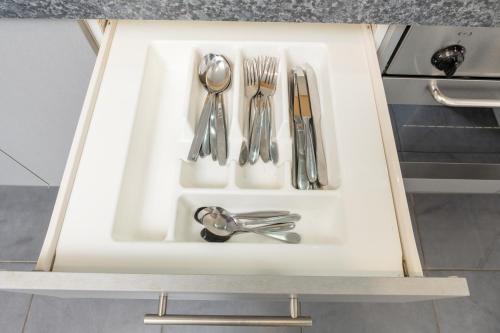 a drawer with silver utensils in a kitchen at Grove Park Motor Lodge in Blenheim