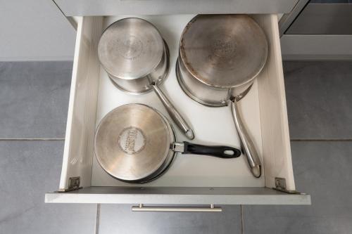 three pots and pans are sitting on a shelf at Grove Park Motor Lodge in Blenheim