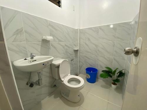 a white bathroom with a toilet and a sink at Panglao Transient house close to nature with bonfire in Panglao