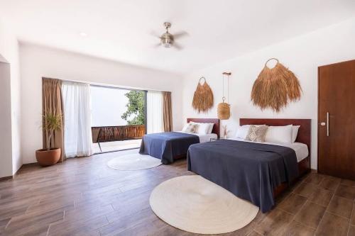 a bedroom with two beds and a large window at La Veleta Hotel - Relax & Recharge - Pool View in Tulum