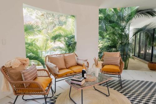 een woonkamer met stoelen en een tafel bij La Veleta Hotel - Peaceful Paradise - Pool View in Tulum