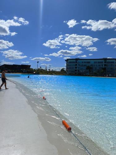 a man walking on a beach with blue water at BEACH HOUSE Mar Adentro, lugar paradisiaco in Santa Cruz de la Sierra