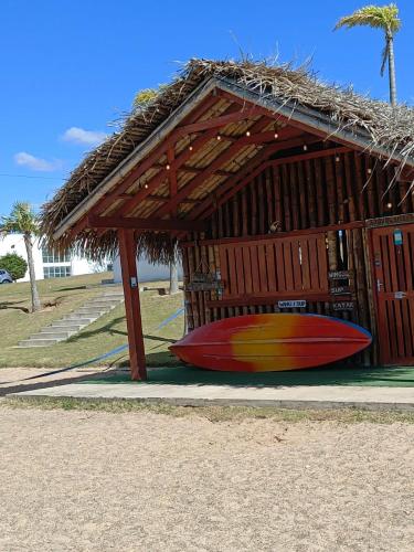 a surfboard laying on the ground in front of a hut at BEACH HOUSE Mar Adentro, lugar paradisiaco in Santa Cruz de la Sierra
