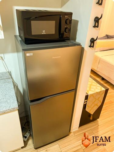 a microwave sitting on top of a refrigerator at JFam Suites, C3-9D Studio, Up To 4 Pax in Biñan