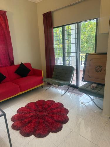a living room with a red couch and a red rug at Green Cove Villa A Famosa Karaoke Netflix Private pool in Simpang Empat