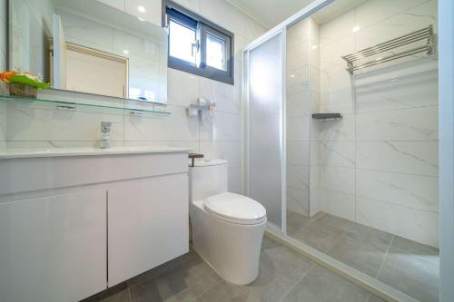 a white bathroom with a toilet and a sink at 海燕民宿 in Suao