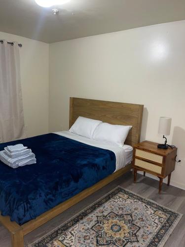 a bedroom with a bed with a blue blanket and a table at Cozy 2 Bedrooms 1and half Bathrooms Near Prudential with Parking Entire Apartment in Newark