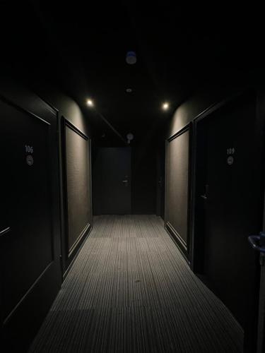 an empty corridor with two doors in a dark room at Hotel Monopol City Centre in Düsseldorf