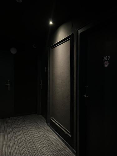 an empty hallway with a door in the dark at Hotel Monopol City Centre in Düsseldorf