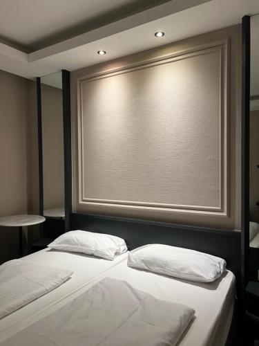 two beds in a room with a large window at Hotel Monopol City Centre in Düsseldorf