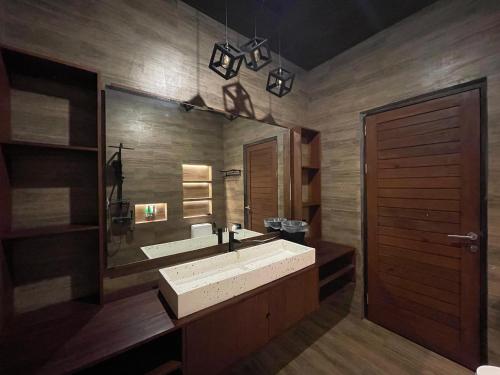 Tanah Lot Dreams Complex Villas By GUMA Hospitality في تاناه لوت: حمام مع حوض كبير ومرآة