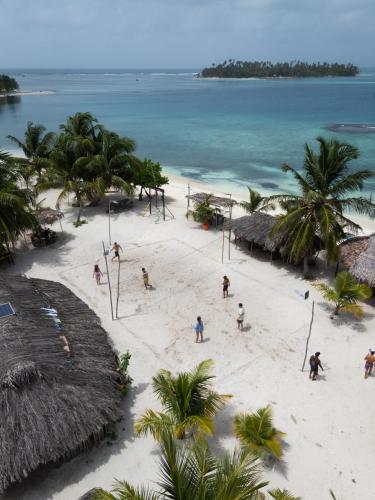 people on a beach with palm trees and the ocean at San Blas Cayos Holandeses, Anaimar 