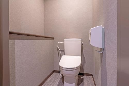 a bathroom with a white toilet in a stall at KAMENOI HOTEL Aso in Aso