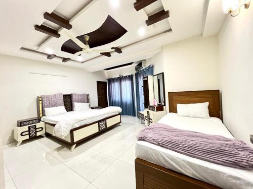 a bedroom with two beds and a ceiling at LUXURY APARTMENT HOTEL islamabad in Islamabad
