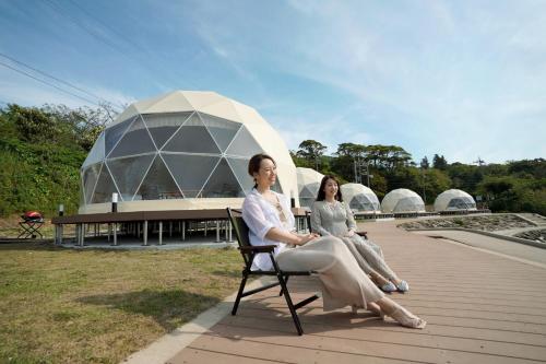two women sitting on a chair in front of a domed building at TADAYOI - Sea Glamping - Camp - Vacation STAY 42099v in Hishi