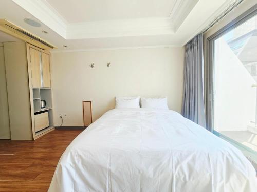 Ένα ή περισσότερα κρεβάτια σε δωμάτιο στο Tongyeong Bay Condo Hotel