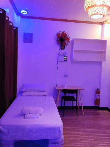 a room with two beds and a table with a fan at Zia Homestay in Burgos