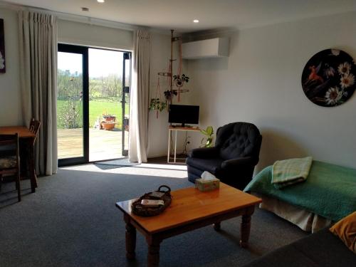 a living room with a couch and a table at Bordeaux Retreat in Te Kauwhata
