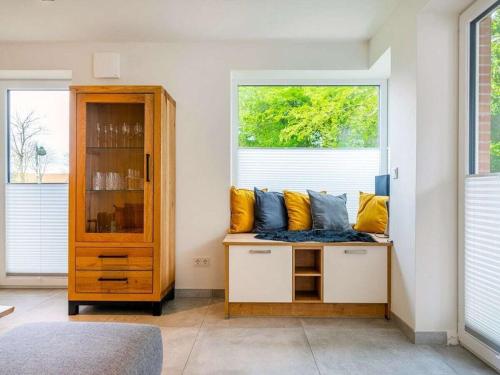 a room with a bench with yellow and blue pillows at Holiday apartment with 2 bedrooms in Greetsiel