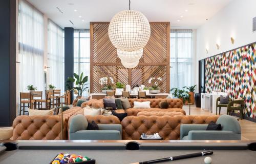 a lobby with couches and a table and chairs at Noho Alexan Modern 2bed Duo with FREE Parking in Garnsey