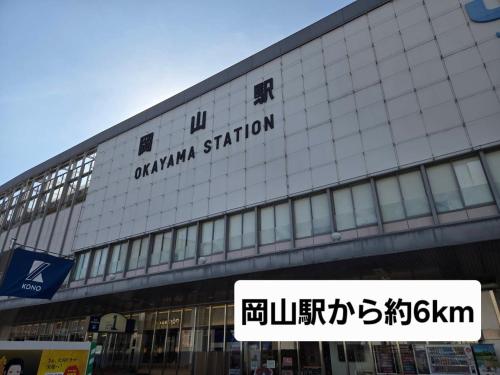 a building with a sign on the side of it at Hotel クージー in Okayama