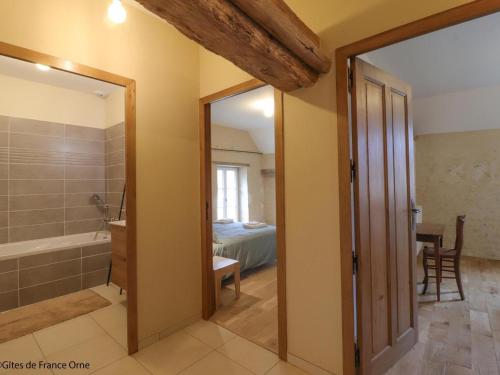 a bathroom with a tub and a bedroom with a bed at Maison indépendante de charme avec jeux et animaux acceptés - FR-1-497-255 in Corbon