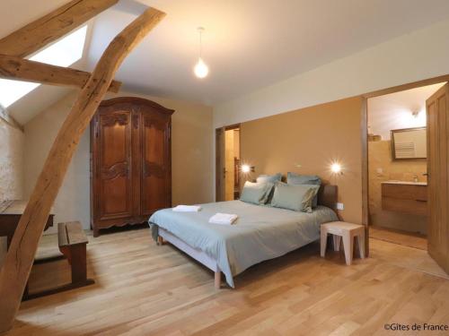 a bedroom with a large bed and a wooden floor at Maison indépendante de charme avec jeux et animaux acceptés - FR-1-497-255 in Corbon