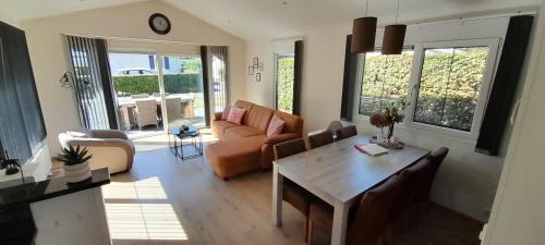 a living room with a table and a couch at Chalet Rosa Livita in De Heen