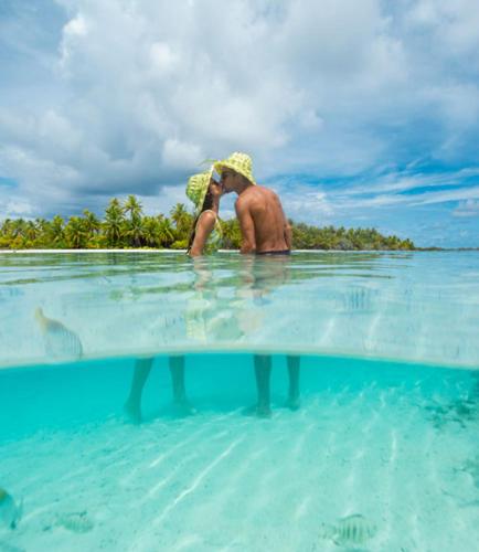 a man standing in the water in the ocean at Noa Noa Lodge in Motu Tiahura