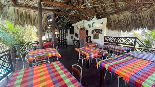 a restaurant with colorful tables and chairs in a room at Marbella Eco Lodge in Monterrico