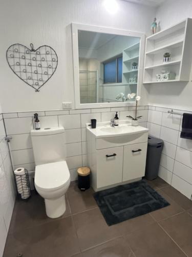 a bathroom with a toilet and a sink and a mirror at Boutique on Russel in Invercargill