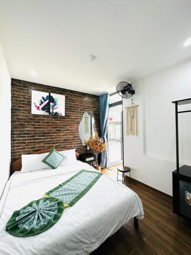 a bedroom with a bed and a brick wall at New World Hotel in Hue