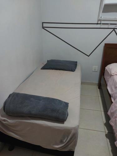 a small bedroom with a bed with a pillow on it at Kit net 7 espaço camila in Maringá