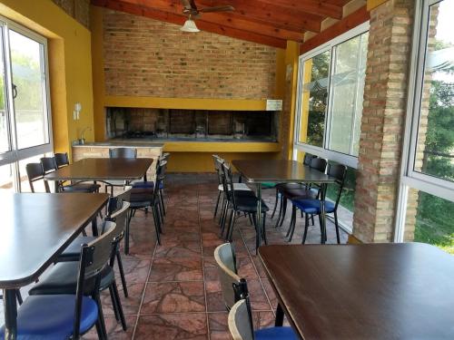 a dining room with tables and chairs and windows at Tu refugio en Miramar con pileta y parrilla in Miramar