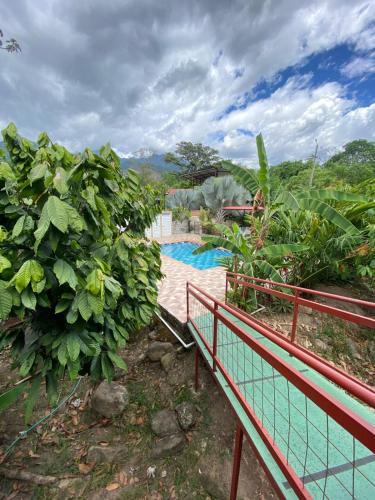 a resort with a pool and a red railing at Hotel Campestre Las Margaritas Rivera in Rivera