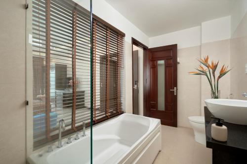 a bathroom with a tub and a sink and a toilet at Banana Garden Hoi An in Hoi An