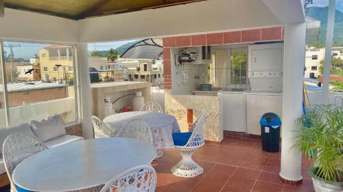 a patio with a table and chairs and a kitchen at A Few Steps to Malecon and Sunny Beaches in Las Flores