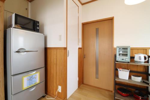 a kitchen with a refrigerator with a tv on top at 日田ホステル　Hita Hostel in Hita