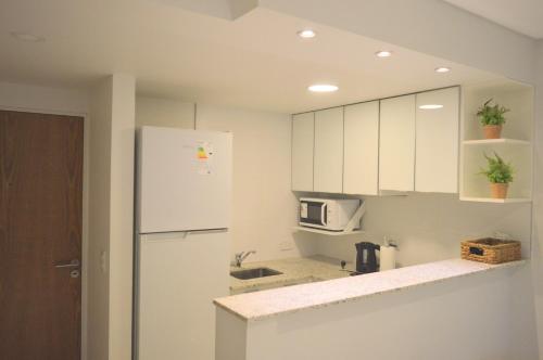 ロサリオにあるDepto Minercoの白いキャビネットと白い冷蔵庫のあるキッチン