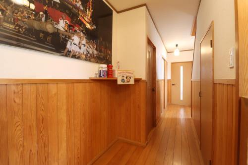a hallway with wooden floors and a painting on the wall at 日田ホステル　Hita Hostel in Hita
