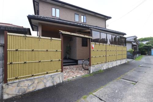 a house with a yellow gate with a bike in it at 日田ホステル　Hita Hostel in Hita