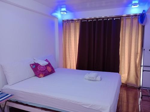 a bedroom with a white bed with a window at Zia Homestay in Burgos