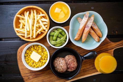 a wooden table topped with different types of food at ITOSHIMA SDGs Village Chikyu MIRAI -海の大パノラマ-全室オーシャンビューのドームテント in Itoshima