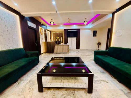 a living room with green couches and a pool table at The ARL Hotels & Banquets in Patna