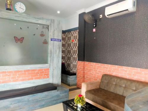 a room with a couch and a clock on the wall at Amber Residency in Ernakulam